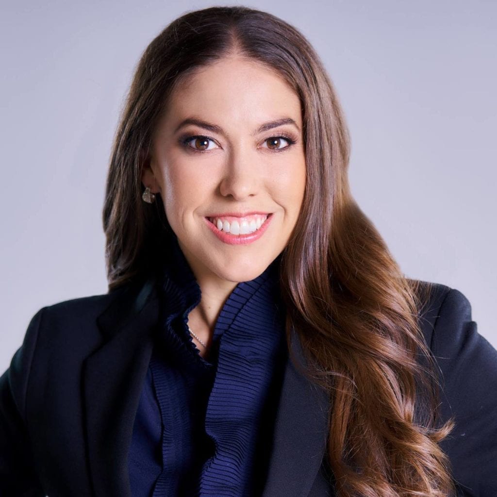 Headshot of Christina Walker, a brunette woman wearing a blue shirt and blue jacket.