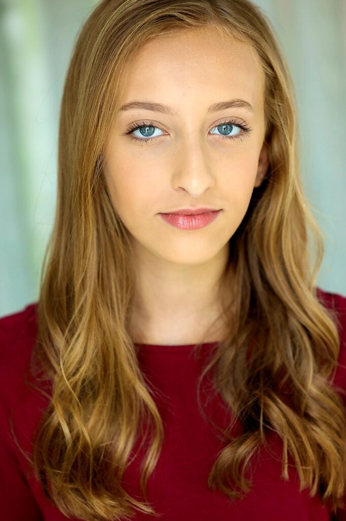 Lyric Knight, a young blonde girl wearing a maroon shirt