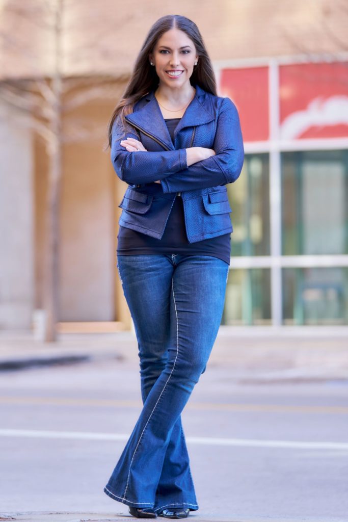 Christina Walker standing up wearing blue jeans and a blue jean jacket.