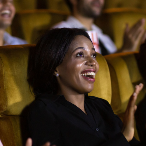 Black mom in audience applauding for her child.