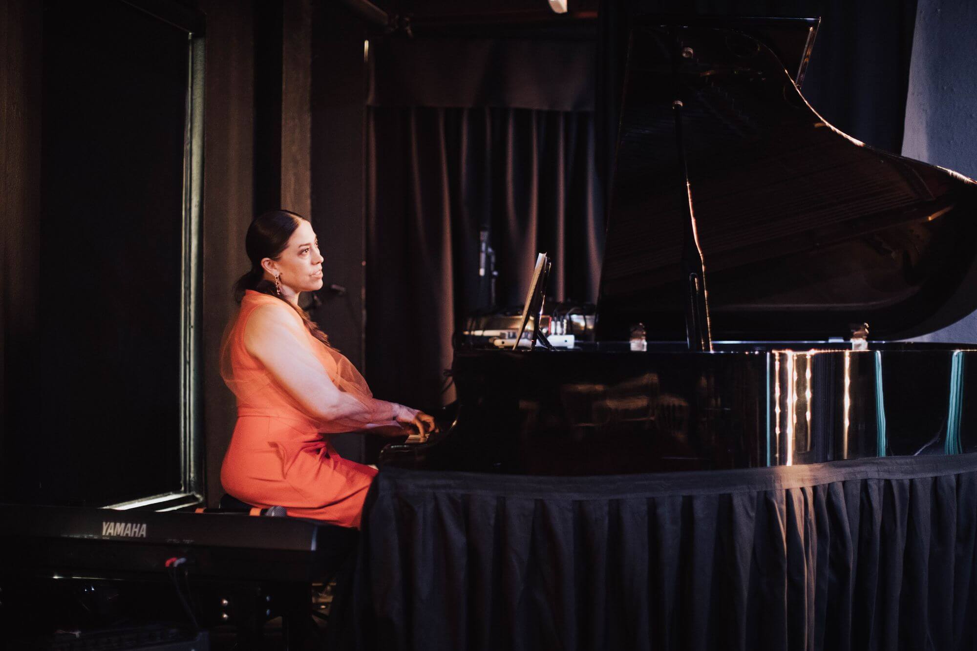 Christina Walker playing grand piano on stage