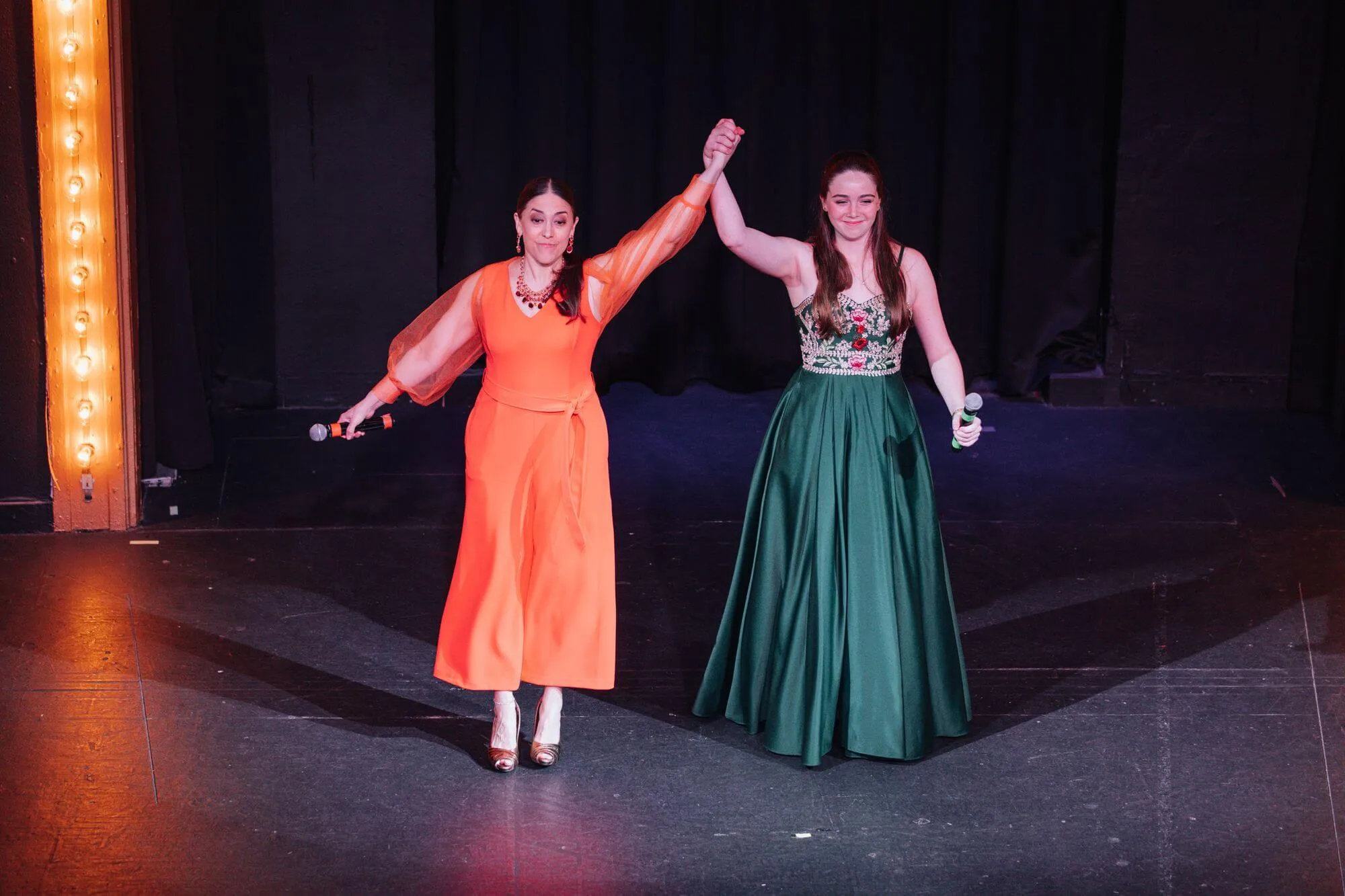 Performing arts performers celebrating on stage after a performance